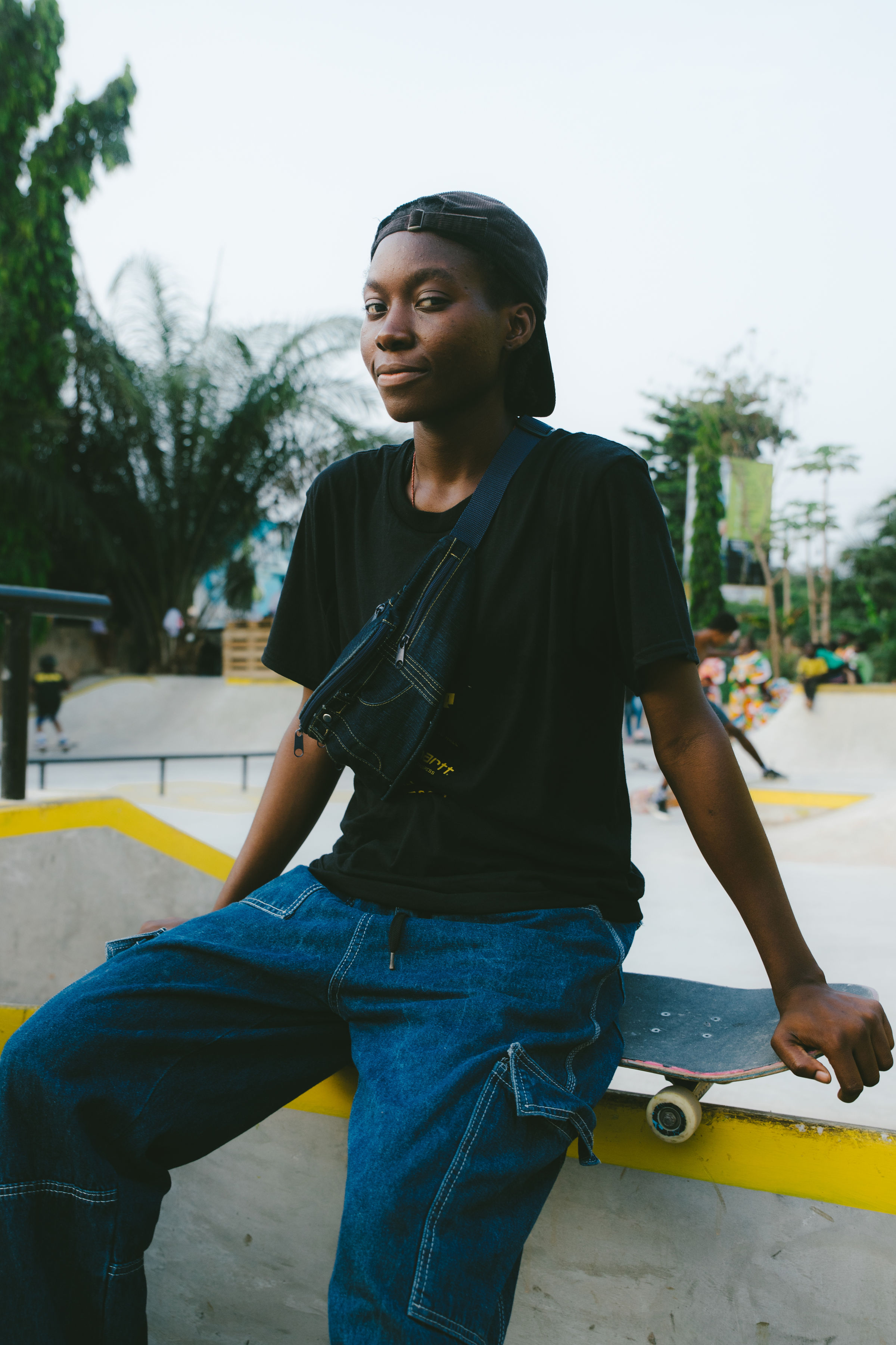 Harmonie Bataka assise sur un obstacle du skatepark, une planche près d’elle