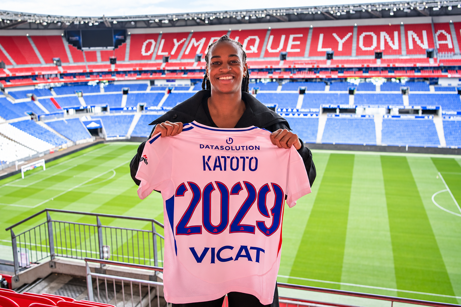 Marie-Antoinette Katoto sourit dans le stade lyonnais en présentant son maillot