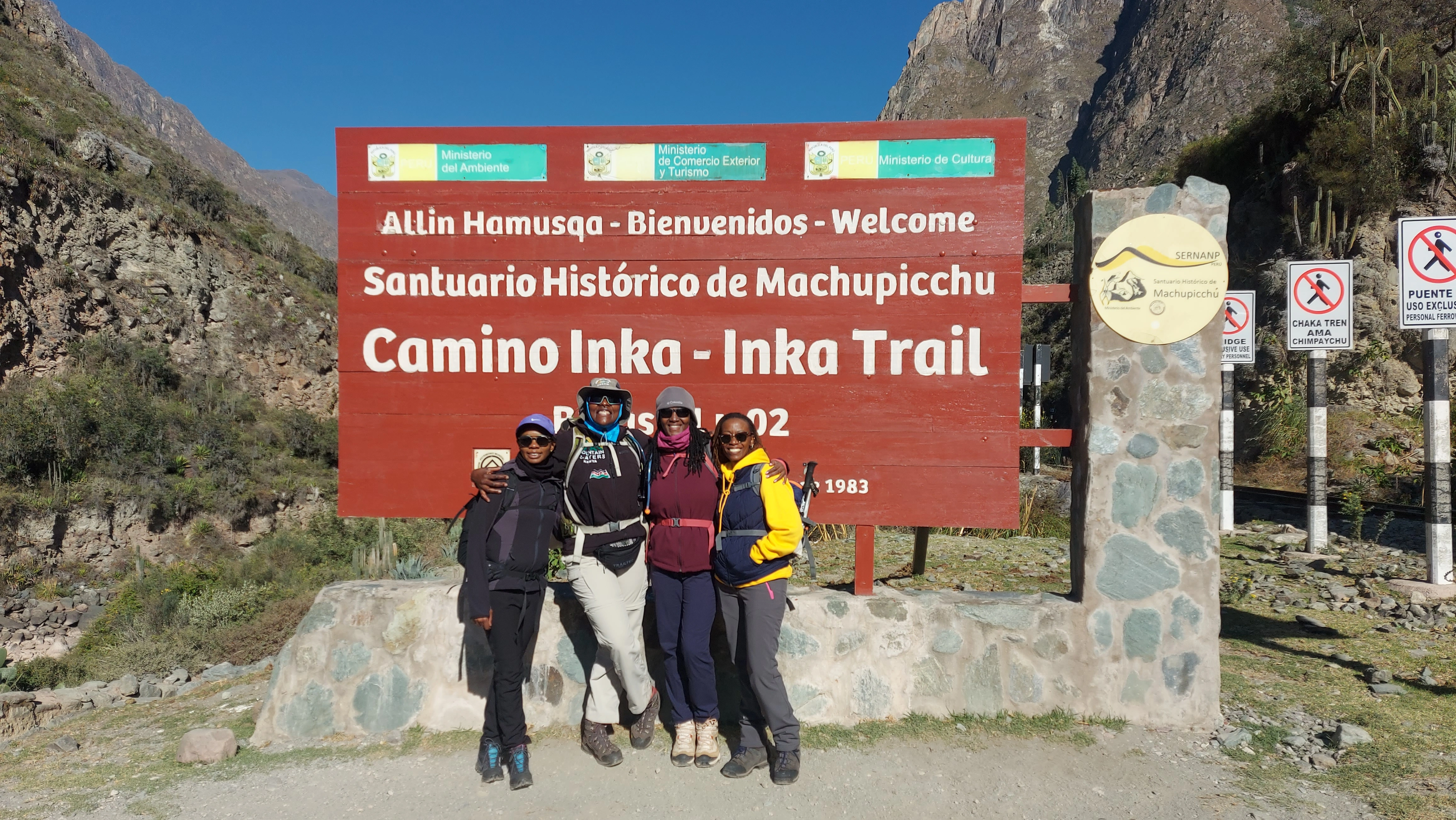 Un groupe de randonneurs devant le panneau du chemin de l’Inca au Machu Picchu