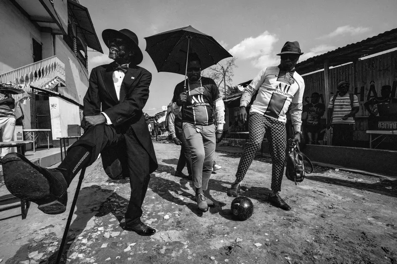 Trois sapeurs dans une rue de Brazzaville, dont deux portant des maillots du PSG, photographiés par Joseph Degbadjo.