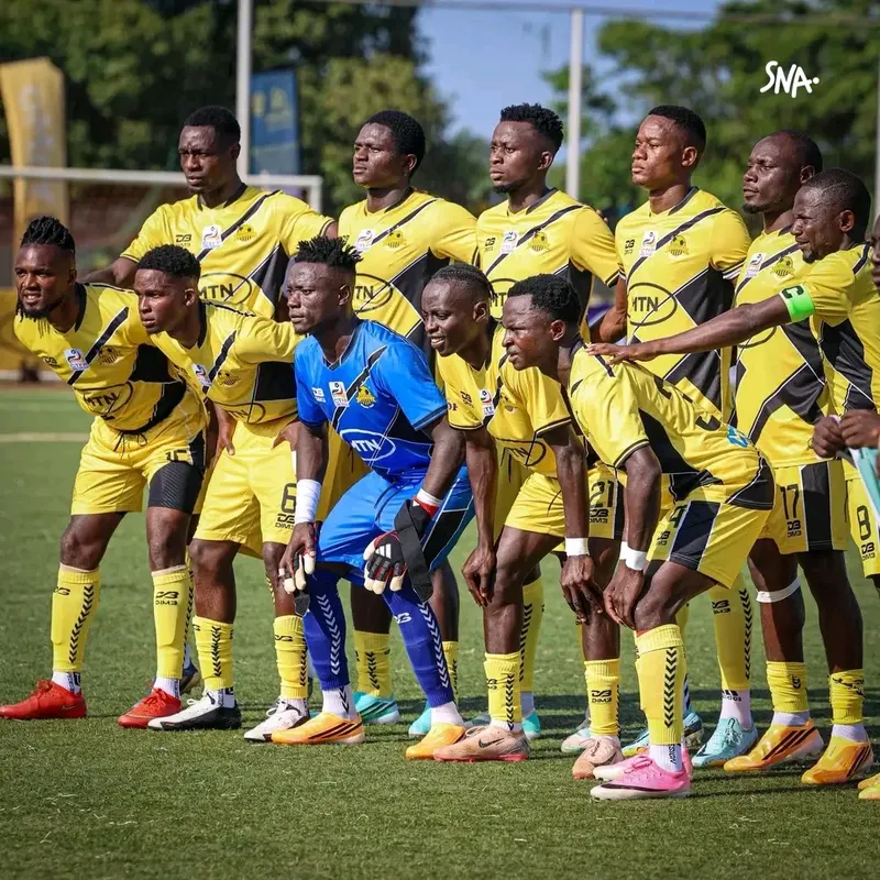 Players of Union sportive d’Abong-Mbang gathered for a team photograph, wearing yellow and black shirts.