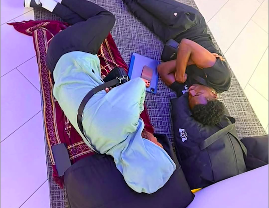 Des joueurs tentant de se reposer à même le sol. Des joueurs tentant de se reposer à même le sol.