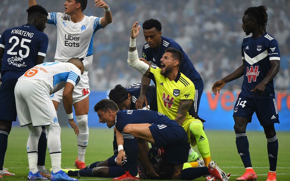 Bordeaux's French goalkeeper Benoit Costil (2nd R) and Bordeaux's French defender Laurent Koscielny (C) call for the medic as Bordeaux's Nigerian forward Samuel Kalu lays on the ground playersduring the French L1 football match between Olympique de Marseille and FC Girondins de Bordeaux at The Stade Velodrome in Marseille, southern France on August 15, 2021. (Photo by Sylvain THOMAS / AFP)