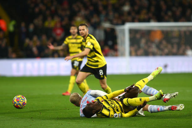 WATFORD, ENGLAND - NOVEMBER 20: Ismaila Sarr of Watford FC is challenged by Donny van de Beek of Manchester United leading to an injury during the Premier League match between Watford and Manchester United at Vicarage Road on November 20, 2021 in Watford, England. (Photo by Charlie Crowhurst/Getty Images)