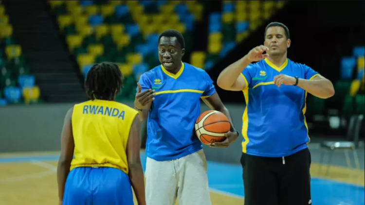 Cheikh Sarr (avec le ballon) donnant des consignes à une joueuse rwandaise.