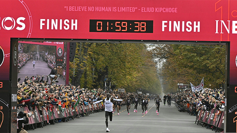 Kenya's Eliud Kipchoge (white jersey) crosses the finish line at the end of his attempt to bust the mythical two-hour barrier for the marathon on October 12 2019 in Vienna. - Kenya's Eliud Kipchoge on Saturday made history, busting the mythical two-hour barrier for the marathon on a specially prepared course in a huge Vienna park.
With an unofficial time of 1hr 59min 40.2sec, the Olympic champion became the first ever to run a marathon in under two hours in the Prater park with the course readied to make it as even as possible. (Photo by HERBERT NEUBAUER / APA / AFP) / Austria OUT