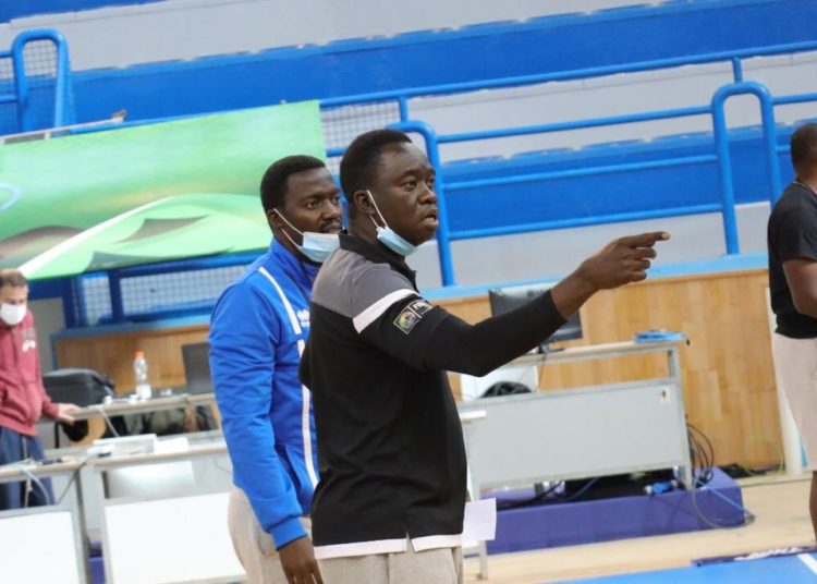 Cheikh Sarr (en noir), le coach de la sélection masculine de basket du Rwanda.