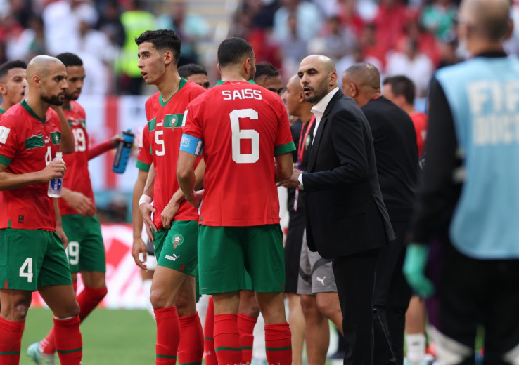 Le sélectionneur du Maroc, Walid Regragui (en costume à droite), donne ses consignes aux Lions de l'Atlas.