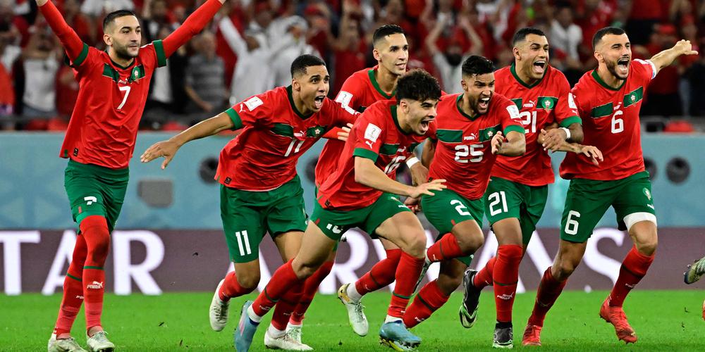 Morocco's players celebrate winning the penalty shoot-out during the Qatar 2022 World Cup round of 16 football match between Morocco and Spain at the Education City Stadium in Al-Rayyan, west of Doha on December 6, 2022. (Photo by JAVIER SORIANO / AFP)