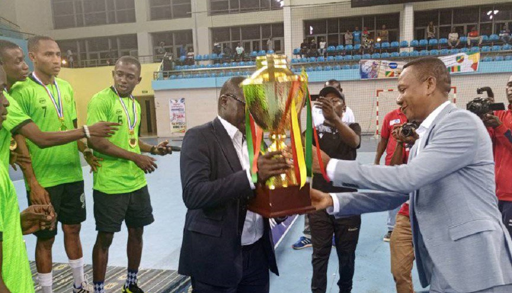 Le président de la FECOHAND remettant le trophée de l'IHF continental à la sélection nigériane.