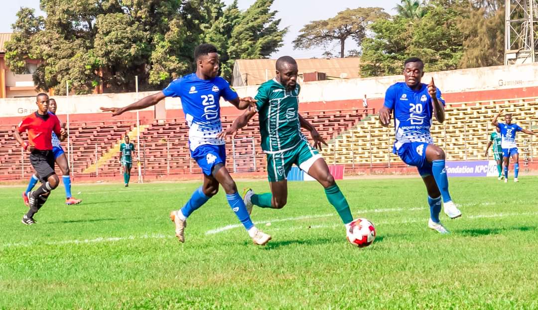 Gaoussou Siby de Hafia FC (vert) au duel avec deux défenseurs de l'ASM Sangaredi 