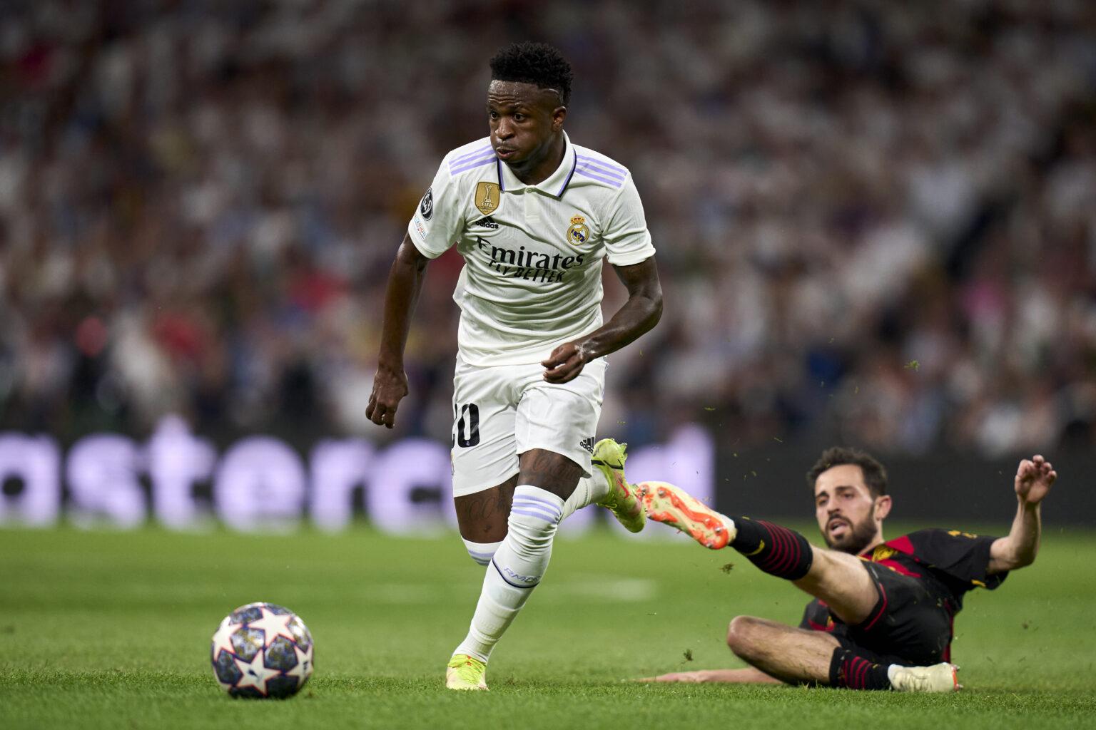 MADRID, SPAIN - MAY 09: Vinicius Junior of Real Madrid battle for the ball with Bernardo Silva of Manchester City FC during the UEFA Champions League semi-final first leg match between Real Madrid and Manchester City FC at Estadio Santiago Bernabeu on May 09, 2023 in Madrid, Spain. (Photo by Diego Souto/Quality Sport Images/Getty Images)