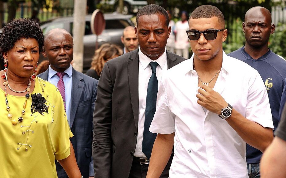 Paris Saint-Germain and France national football team star striker Kylian Mbappe (2nd R) leaves after a meeting with the Prime Minister of Cameroon Joseph Ngute at the Prime Minister's office in Yaounde on July 7, 2023 during a charity visit and a tour of his father's village. (Photo by Daniel BELOUMOU OLOMO / AFP)