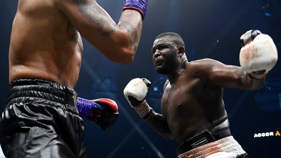 Congolese Martin Bakole (R) throws a jab at France's Tony Yoka in his International Heavyweight 10-round boxing bout at The AccorHotels Arena in Paris on May 14, 2022. (Photo by FRANCK FIFE / AFP)