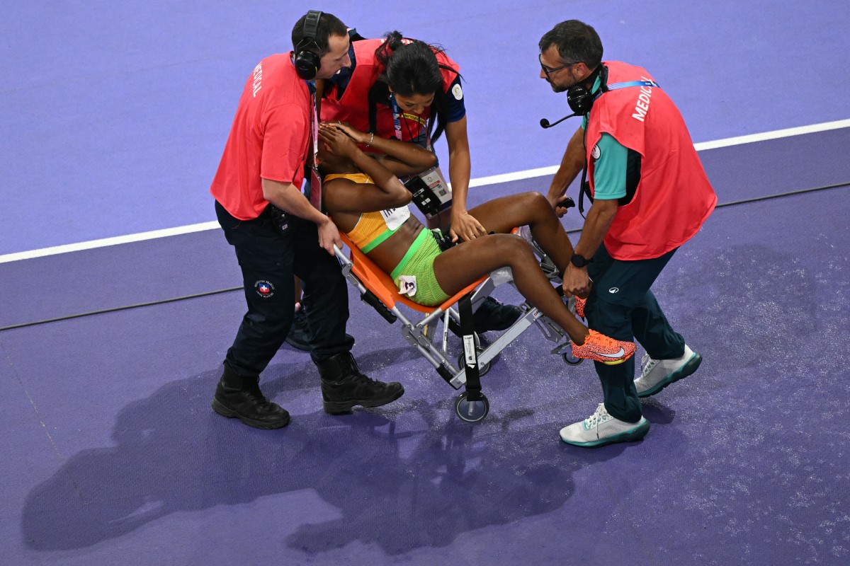 Ivory Coast's Marie Josee Ta Lou-Smith leaves with medical staff in the women's 100m final of the athletics event at the Paris 2024 Olympic Games at Stade de France in Saint-Denis, north of Paris, on August 3, 2024. (Photo by JUNG Yeon-je / AFP)