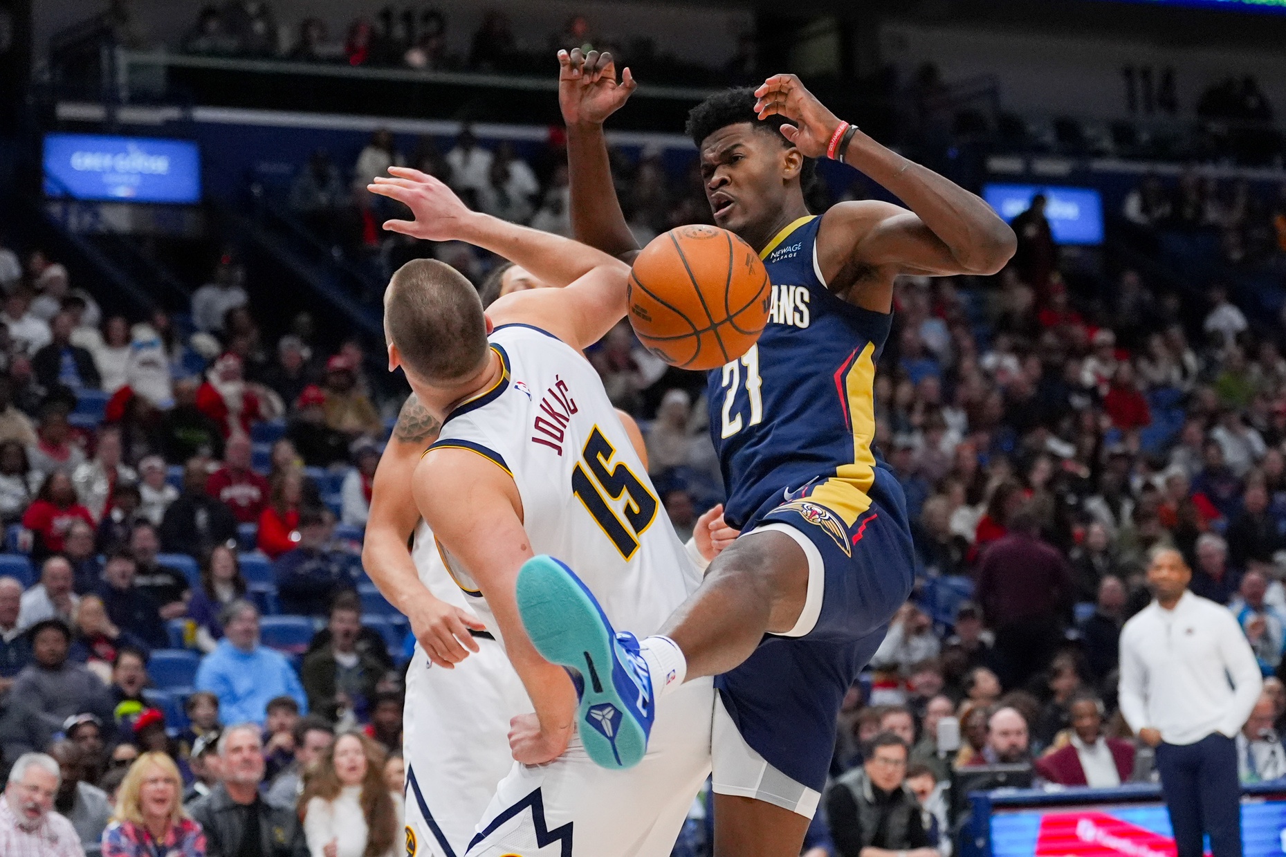 Dec 22, 2024; New Orleans, Louisiana, USA; New Orleans Pelicans center Yves Missi (21) comes down from a dunk against Denver Nuggets center Nikola Jokic (15) during the first half at Smoothie King Center. Mandatory Credit: Matthew Hinton-Imagn Images